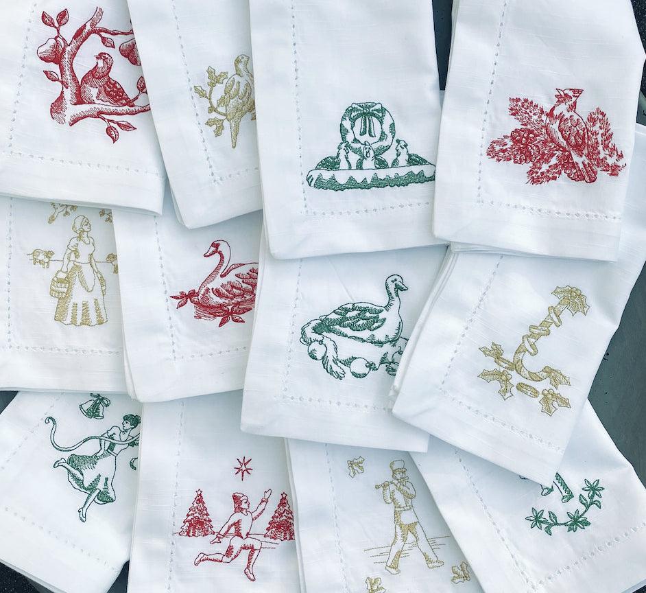 https://whitetulipembroidery.com/cdn/shop/products/twelve-days-of-christmas-embroidered-cloth-napkins-set-of-12-napkins-white-tulip-embroidery-1_a68eb0b6-91c9-47b6-ace5-f1f2c3dca382.jpg?v=1676306313