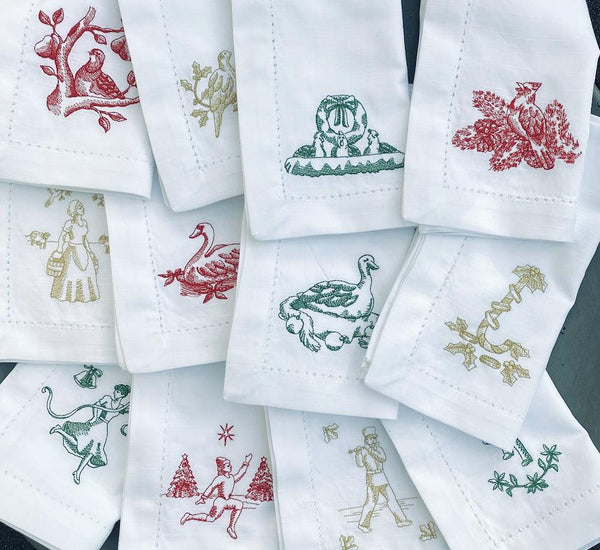 https://whitetulipembroidery.com/cdn/shop/products/twelve-days-of-christmas-embroidered-cloth-napkins-set-of-12-napkins-white-tulip-embroidery-1_a68eb0b6-91c9-47b6-ace5-f1f2c3dca382_grande.jpg?v=1676306313